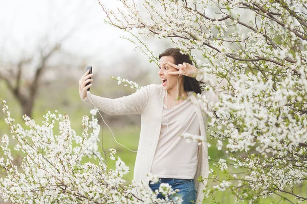 Young fun crazy woman in casual clothes with earphones listening