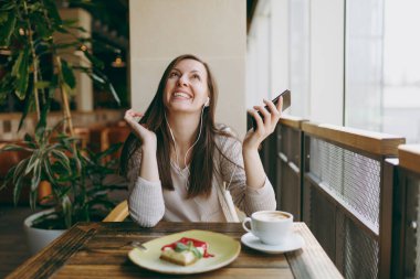 Kafede cappucci fincan masada oturan genç kadın