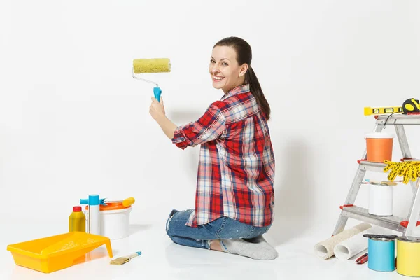 Όμορφη γυναίκα που κάθεται στο πάτωμα με ρολό βαφής, όργανα για δωμάτιο διαμέρισμα ανακαίνιση που απομονώνονται σε λευκό φόντο. Ταπετσαρία, αξεσουάρ για την κόλληση, εργαλεία ζωγραφικής τοίχων. Επισκευή concept home. — Φωτογραφία Αρχείου