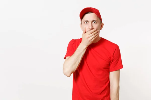 Repartidor en uniforme rojo aislado sobre fondo blanco. Profesional grave sorprendido macho en la tapa, camiseta que trabaja como mensajero o distribuidor, cubrir la boca con gesto de la mano. Copiar espacio para publicidad . — Foto de Stock