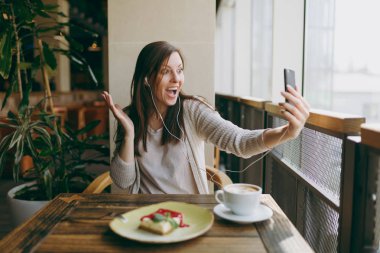 Tek başına ca fincanla kafede masada oturan genç kadın