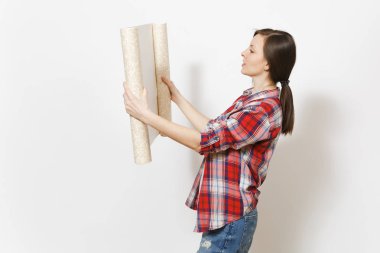 Rahat kıyafetler unrolled duvar kağıdı arıyorum genç ciddi güzel kadında rulo üzerinde izole beyaz arka plan. Aletleri, aksesuarları, yenileme daire oda için araçlar. Onarım ev concept