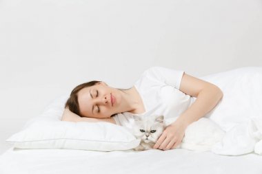 Sakin genç kadın beyaz sevimli Farsça gümüş chinchilla kedi, sac, yastık, battaniye beyaz arka plan üzerinde ile yatakta yalan. Odada vakit geçirmek güzellik kadın. Dinlenmek, iyi bir ruh hali kavramı sakin ol. Kopya alanı