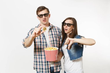 Genç memnun çift, kadını ve Kova patlamış mısır ve beyaz arka plan üzerinde izole bitcoin tutan adam 3d gözlük ve rahat kıyafetler tarihte, film film izlerken. Sinema kavramı duygular