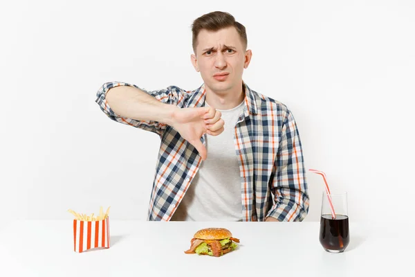 ハンバーガー フライド ポテト 白い背景で隔離のガラスでコーラのテーブルに座っているハンサムな若い男 適切な栄養やアメリカの古典的なファーストフード 広告コピー スペース付きのエリア — ストック写真