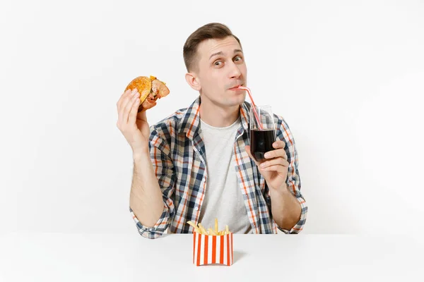 ハンバーガー フライド ポテト 白い背景で隔離のガラスでコーラのテーブルに座っているハンサムな若い男 適切な栄養やアメリカの古典的なファーストフード 広告コピー スペース付きのエリア ストック画像