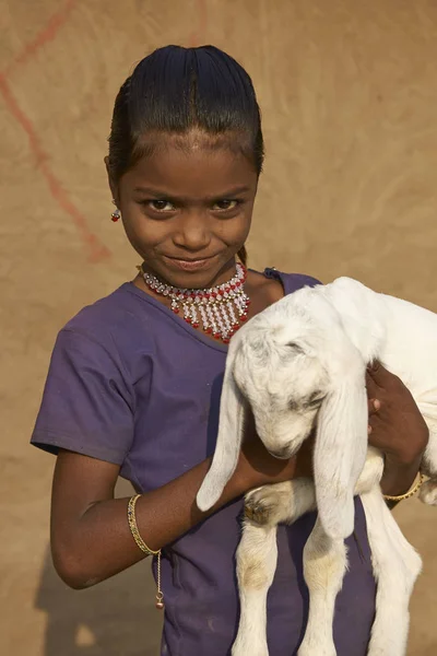 Chica joven sosteniendo un cabrito cabra —  Fotos de Stock