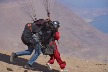 Iquique, Tarapaca bölge, Şili - 20 Ağustos 2017: Iquique kıyı şehri kuzey Şili sahil üzerinde yukarıda bir uçurumdan Tandem Yamaç paraşütü başlatma.
