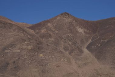 Large group of ancient petroglyphs on the hillsides at Cerro Pintados in the Atacama Desert in the Tarapaca Region of northern Chile.  clipart