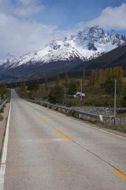 Carretera Austral; ünlü yolu uzak kasaba ve köylerde Kuzey Patagonia, Şili'deki bağlanma. Dağlar yakınındaki küçük kasaba, Cerro Castillo kar çalışan yol asfalt bölüm şapkalı. 