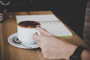 Bir fincan kahve tutan kadın.