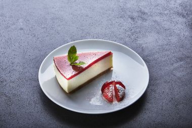 Çilekli cheesecake çilek ile şeker serpilir