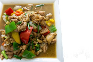 Biberle kızartılmış tavuk ve kare beyaz seramik bir tabağa konur..