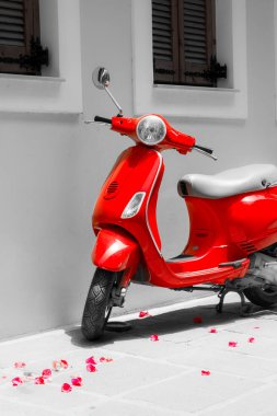 Kırmızı motor scooter. Gül yaprakları, güneşli gün ve siyah-beyaz fotoğraf. Girit antik cadde.