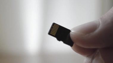 Adam elinde siyah mikro Sd kartı tutar