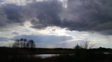 Önünde kara bir yağmur bulutu olan güzel bir gün batımı.