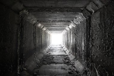 Sonunda ışık olan boş kare beton bir tünel. Kurumuş menfez.