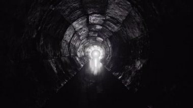Yuvarlak drenaj beton tünel, biçimsel çalışmayla inşa edilmiş su. Sonunda ışık var. Tüpün içine gizlenmiş yeraltı nehri.