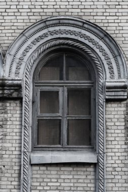 Stalinist imparatorluk tarzında terk edilmiş eski bir binanın tuğla duvarındaki eski ağrılı pencere..