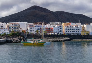 La Restinga, El Hierro / İspanya; 5 Nisan 2019: La Restinga limanı, şehir manzarası, volkan ve gri bulutlar arka planı, El Hierro, Kanarya adaları, İspanya