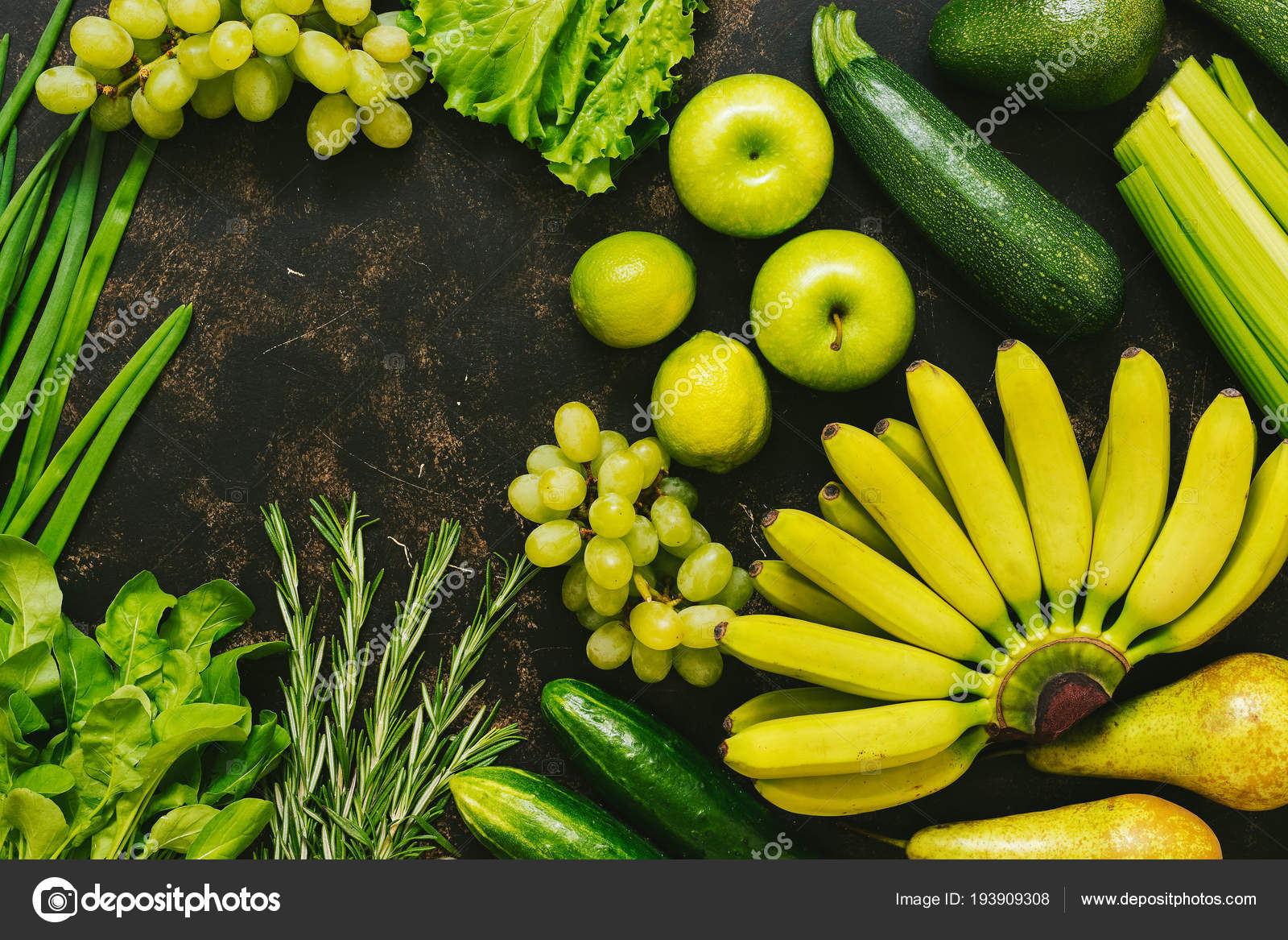 Fresh green and yellow fruits and vegetables on a dark background, top ...