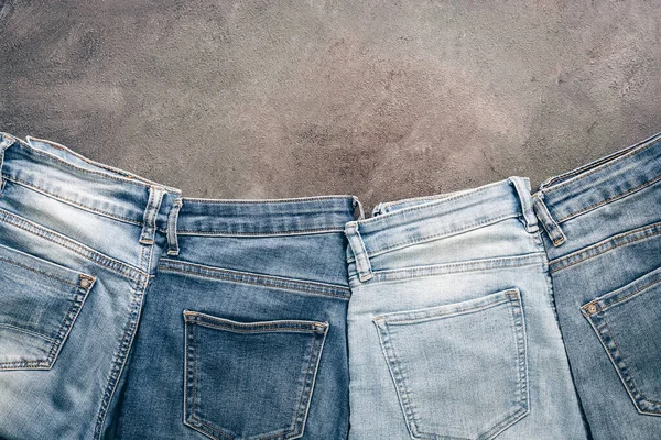 Flat lay collection of fashionable denim blue jeans, border. Top view, flat lay, copy space.