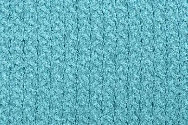 Turquoise knitted texture background with a pattern, closeup. Abstract texture of woolen fabric.