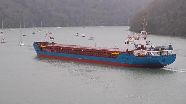 Cargo ship making its way in driving rain up the Truro river near Malpas in Cornwall UK — Stock Photo, Image