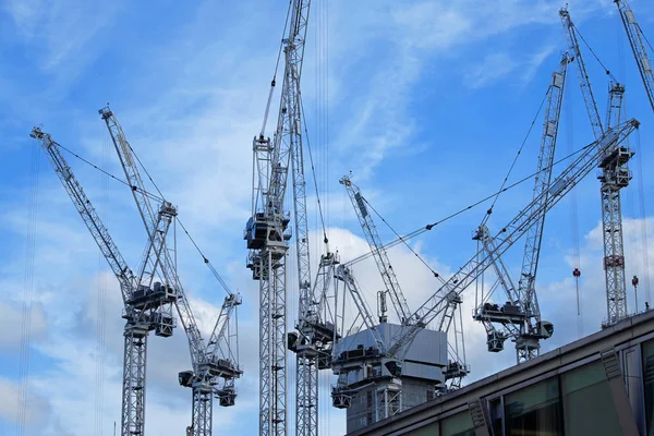 Turmdrehkräne auf einer britischen Baustelle vor blauem Himmel — Stockfoto