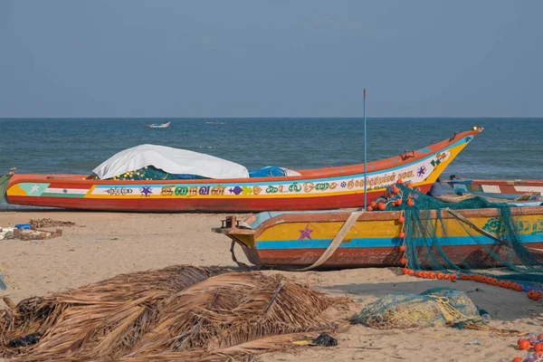 Part of the local fishing fleet stranded on the beach at Mamallapuram in Tamil Nadu, India. The main catches taken in the Bay of Bengal inshore fishery are pomfrets and prawns