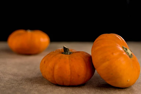 Pequenas abóboras laranja sazonais com fundo texturizado — Fotografia de Stock