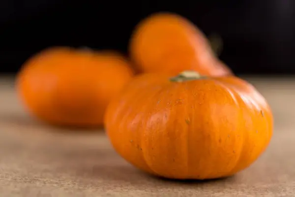 Pequenas abóboras laranja sazonais com fundo texturizado — Fotografia de Stock