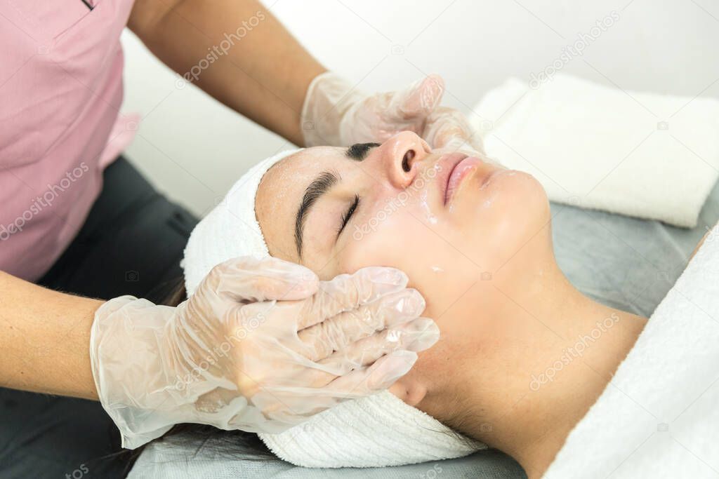 Expert cosmetologist making a deep cleansing facial