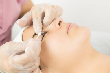 Kirpik tedavisi genç bir kadına uygulanır.