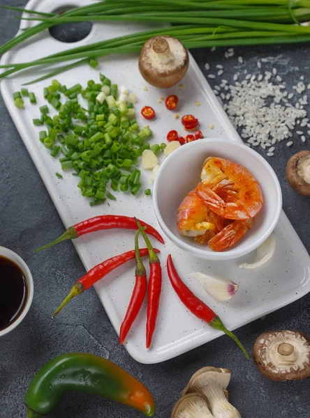 Asiatisches Essen auf dunklem Hintergrund, Wokreis mit Garnelen und Pilzen, während der Zubereitung — Stockfoto