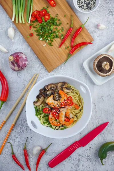 Hot asian wok noodles with shrimps and mushrooms, Preparation ramen, Gray background, Top view