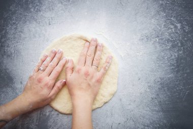 Ev yapımı pizza, Eller pizza yapmak için hamur yoğurur.