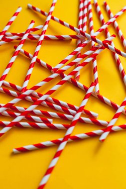 Sarı arka planda kırmızı kokteyl pipetleri