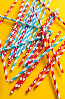 Sarı arka planda çok renkli kokteyl pipetleri