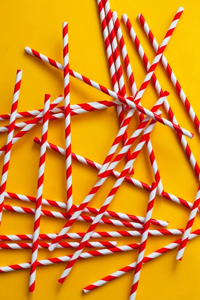 Red cocktail straws on a yellow background