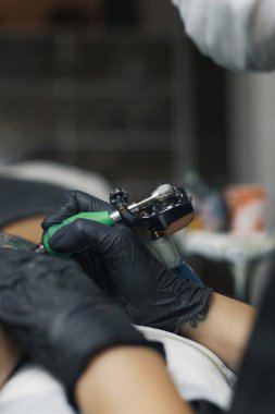 Dövme ustası kız dövme yapar.