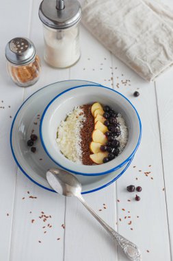 Beyaz arka planda kahvaltıda elmalı ve üzümlü Semolina lapası.