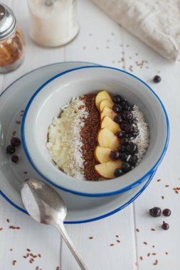 Beyaz arka planda kahvaltıda elmalı ve üzümlü Semolina lapası.