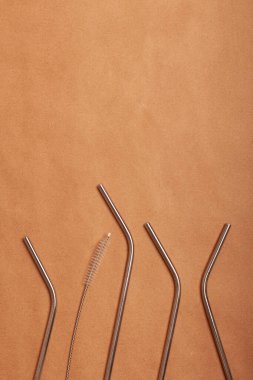 Çevre dostu metal kokteyl pipetleri el sanatları kağıdının arka planında. Üst görünüm