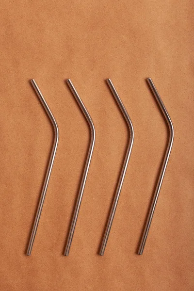 Eco-friendly metal cocktail straws on a background of craft paper. Top view