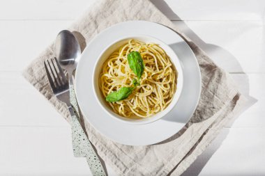 Beyaz bir kasede, beyaz bir arka planda, güneş ışığında makarna.