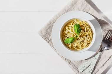 Beyaz bir kasede, beyaz bir arka planda, güneş ışığında makarna.