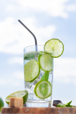 Güneşin altında gökyüzüne karşı mojito serinletiyor