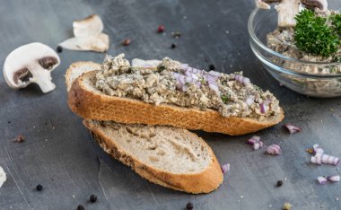 Tüm renkli biber ve mantar parçaları gri bir arka plan üzerinde taze pasta champignon ile yayıldı