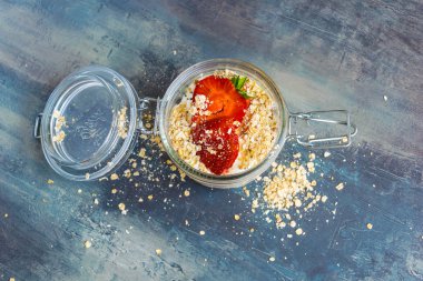 Bir bardak çikolata topları, yulaf ezmesi ve meyve ile lezzetli beyaz yoğurt